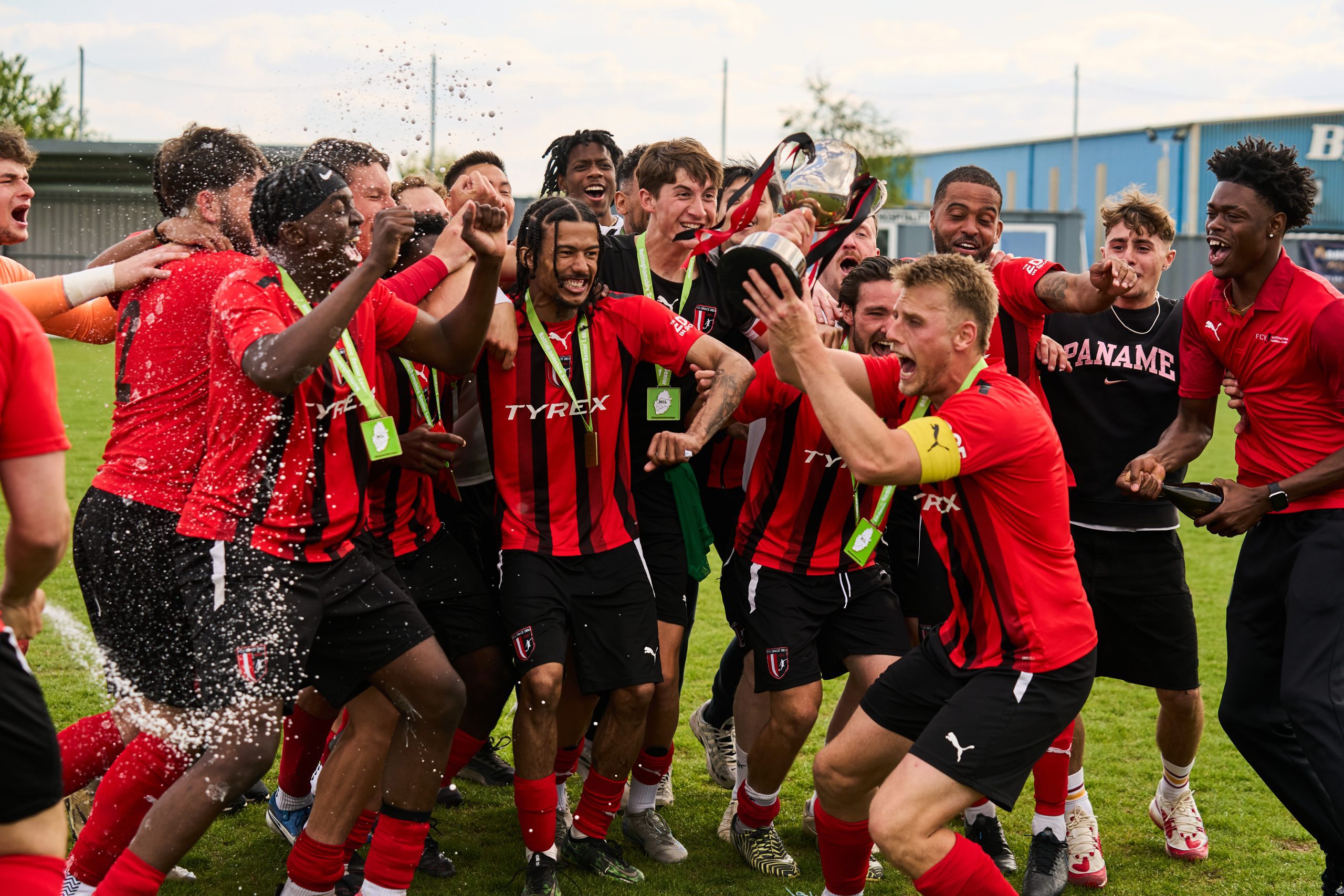 FCV Grace Dieu captain Joe Lindley lifting the cup and celebrating with teammates